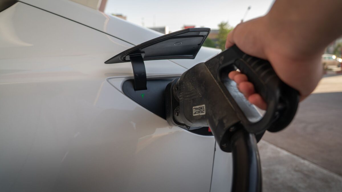 Close-up of electric car being charged, highlighting eco-friendly transportation.