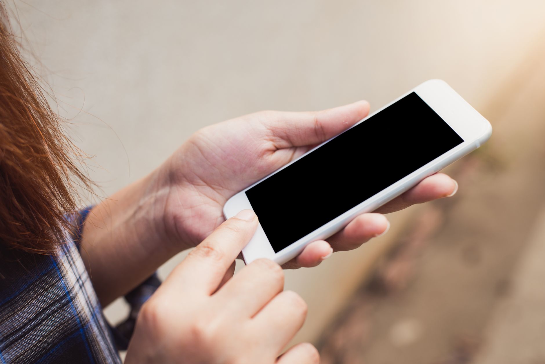 Eine Person hält ein Smartphone in den Händen und berührt das Display.